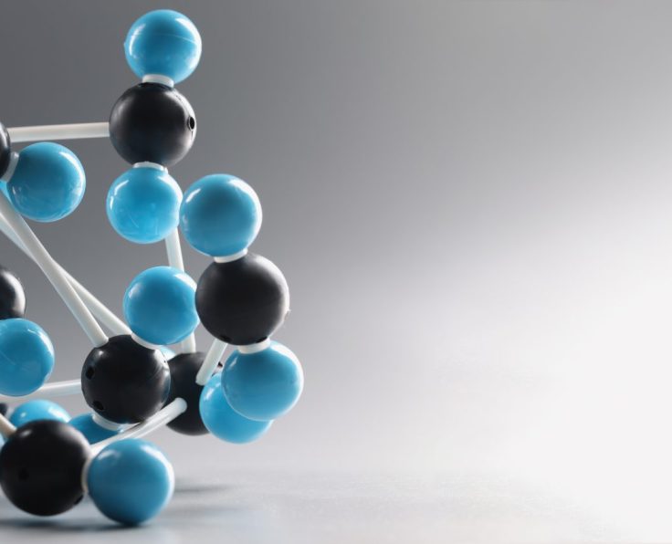 Close-up of molecular model structure, miniature on grey background, blue and black cells connected to each other. Laboratory, chemistry, science concept